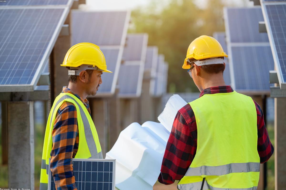 Technicians in safety gear inspecting a solar installation on site